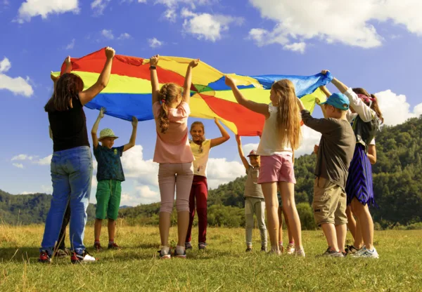 People holding a rainbow parachute